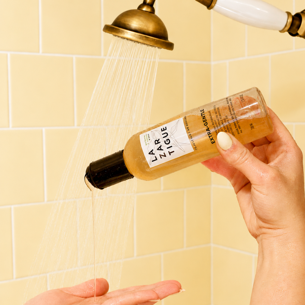 Lazartigue – Shampoing Extra-Gentle 200Ml (Shampoing Extra-Doux Usage Fréquent), en person hælder et plejeprodukt op i hånden i badet