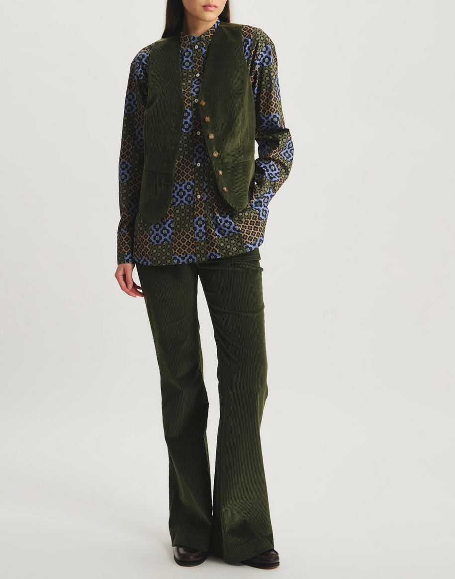 Ines De La Fressange – Gilet Sanite - Verde Oliva, modella che indossa una camicia a motivi, un gilet e pantaloni svasati