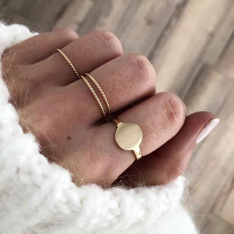 Instants Plaisirs – Bague "Louise" Plaqué Or, main de femme portant des bagues dorées, pull blanc en maille