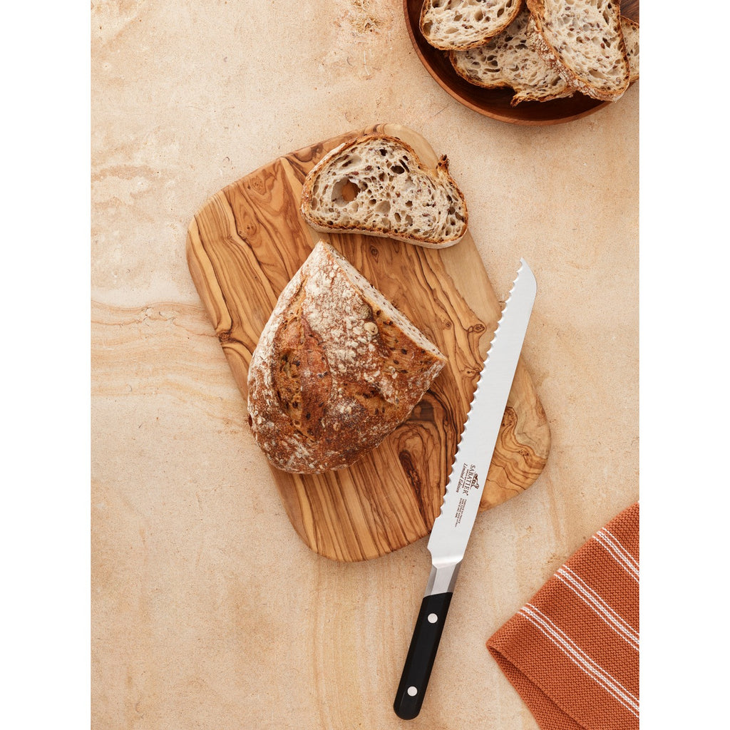 De Buyer – Sabatier Edizione Limitata - Coltello Da Chef - Inox - Nero, pane casereccio affettato su un tagliere di legno, con un coltello da pane