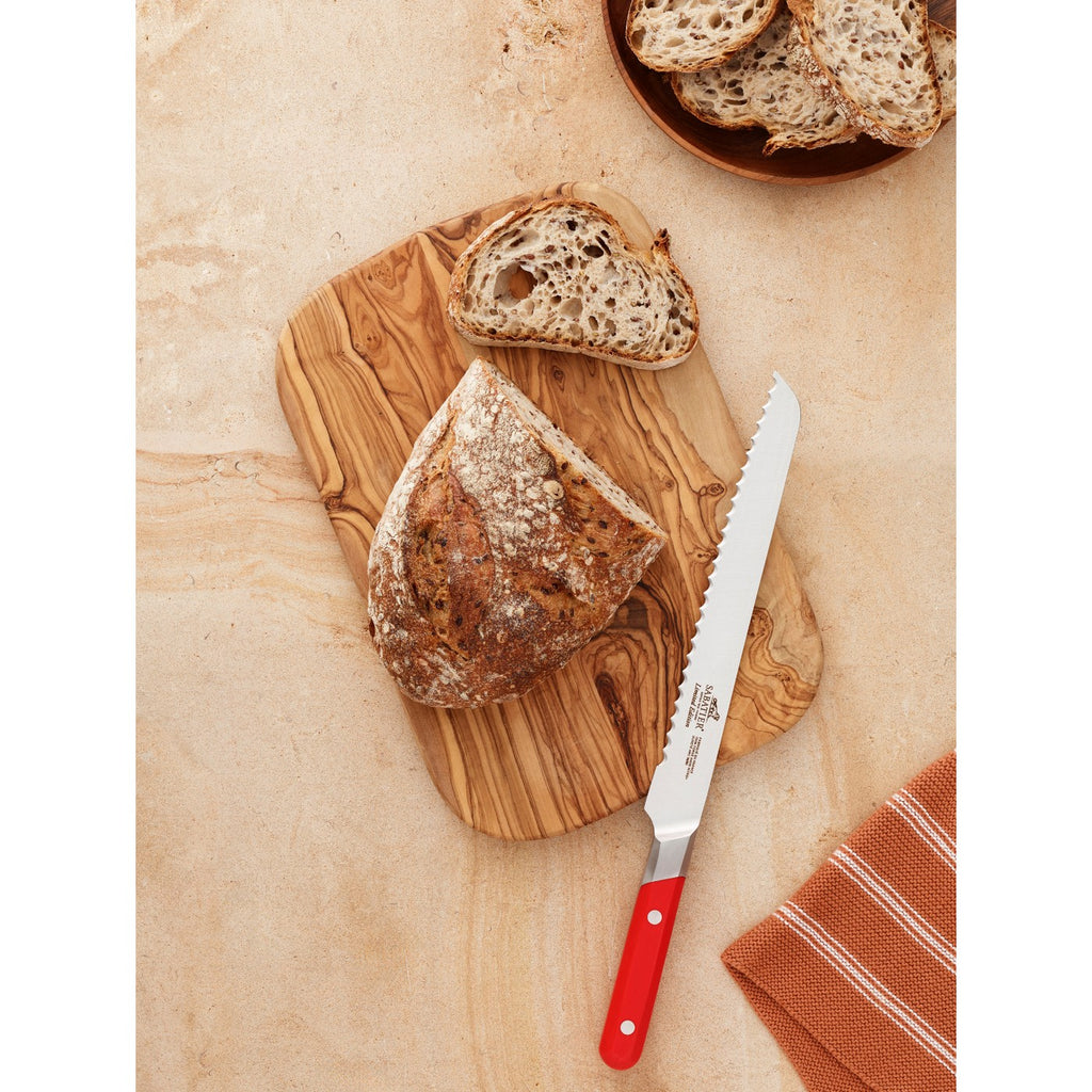 De Buyer – Sabatier Édition Limitée - Brødkniv - Rustfrit stål - Rød, rød og hvid brødkniv på et træbræt med brød