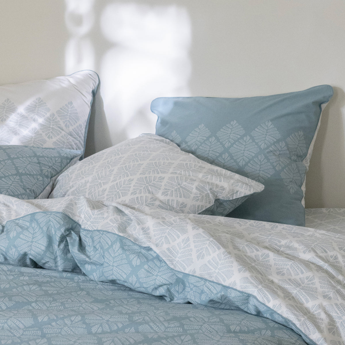 Blanc Cerise – Pointe De Douceur - Pillowcase - Storm Blue, blue and white bed linen set with botanical patterns, on a bed