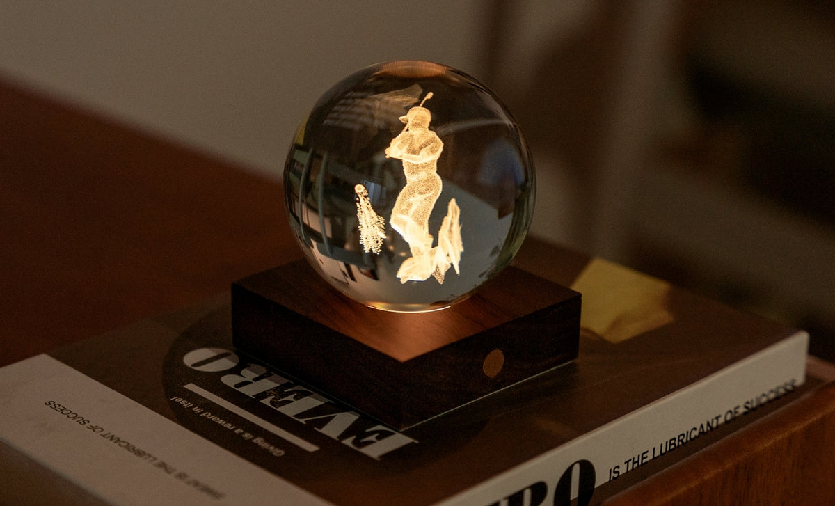 Gingko Design – Amber Crystal Light - Golf, een oplichtende glazen bol op een houten voet