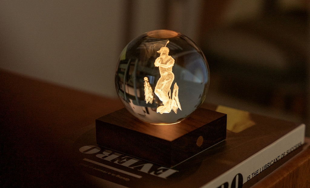 Gingko Design – Amber Crystal Light - Golf, een kristallen bol gegraveerd met een honkbalspeler, op een houten voet