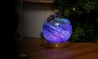 Gingko Design – Leuchte Astraglass - Stellar Ocean - 2 Größen, kugelförmige Tischlampe aus lila und blauem Glas auf Holzsockel