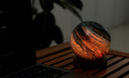Gingko Design – Astraglass Leuchte - Stellar Ocean - 2 Größen, kugelförmige Leuchtschreibtischlampe auf einem Holztisch