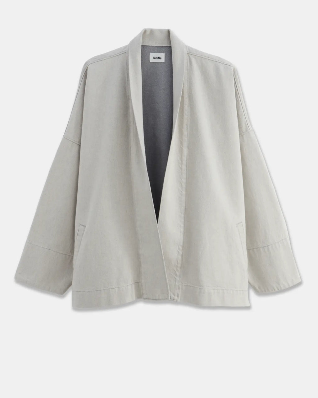 Loose jacket in lightweight, undyed granite-colored cotton, with a shawl collar and wide sleeves, perfect for a relaxed and comfortable silhouette.