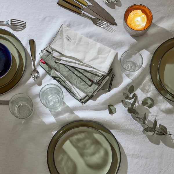 Blanc Cerise – Linne i fokus – Bordsduk – Linne – Vit med linnefärgad broderad kant, dukat bord med tallrikar, glas och tygservetter