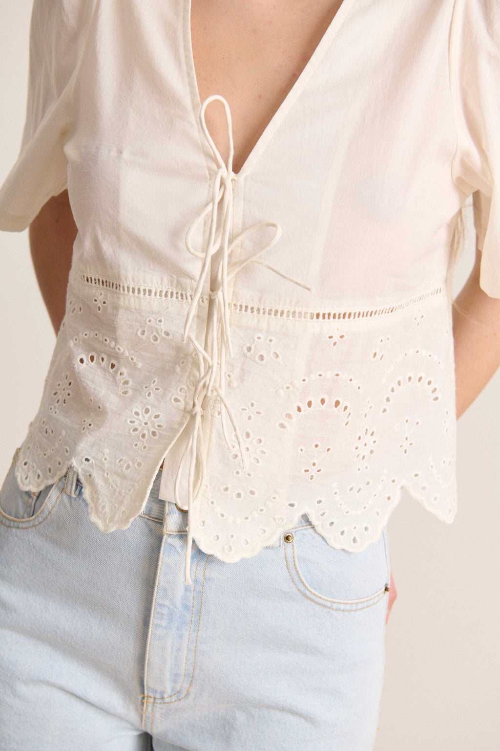 Blusa corta 100% algodón con manga corta y frunces en los hombros con cierre de tres lazos en la parte delantera de la blusa