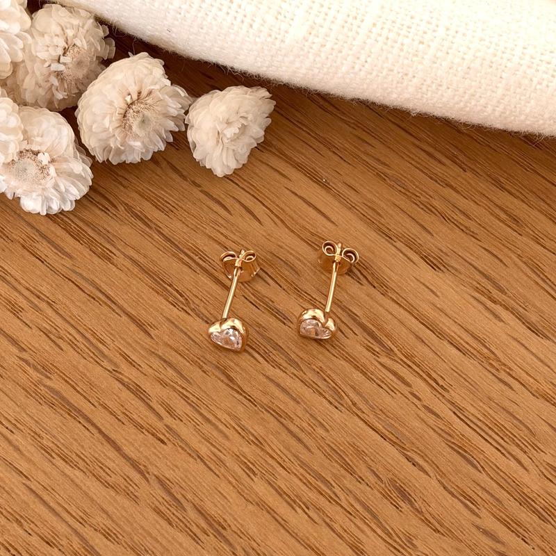 Instants Plaisirs – Boucles D'Oreilles "Aena" Plaqué Or, deux boucles d'oreilles dorées en forme de cœur sur bois clair