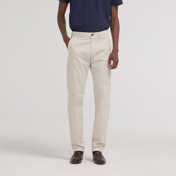 Hast – Råvita Chinos, beige byxor burna av en man, framifrån
