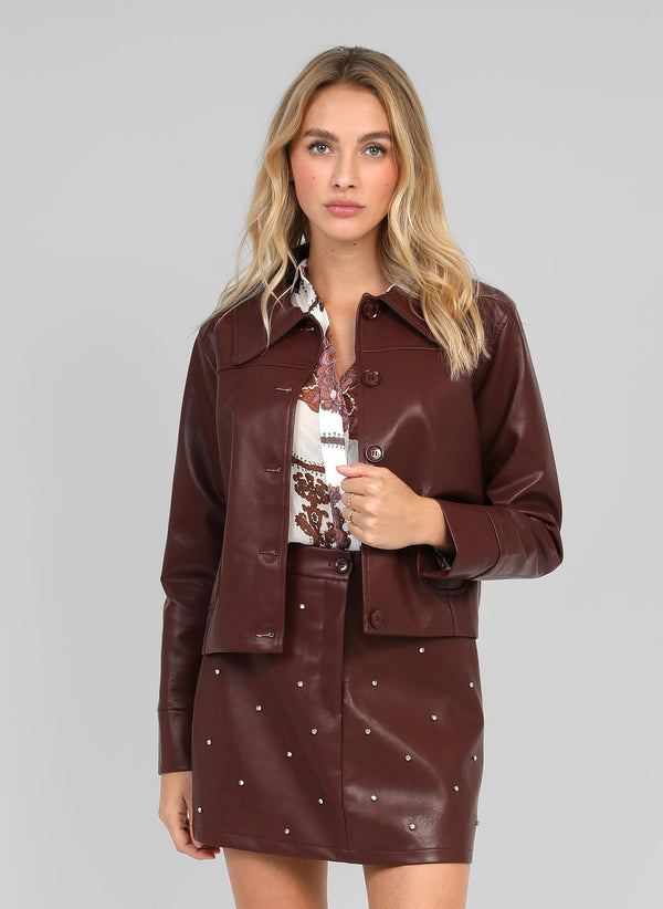 An'ge – Claudiane Wine jacket, model wearing a brown leather jacket and skirt, front view