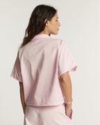 Pantalon en popeline rose clair, coupe droite et ajustée, matière légère et douce idéale pour l'été, conçue pour s'adapter à toutes les morphologies féminines.