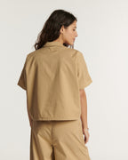 Pantalón de popelín beige, corte recto y fluido, material ligero de algodón apto para todo tipo de cuerpo para un estilo cómodo y veraniego.