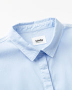 Cuello camisero azul claro en popelina ligera, tejido suave y transpirable ideal para un estilo veraniego elegante y confortable.
