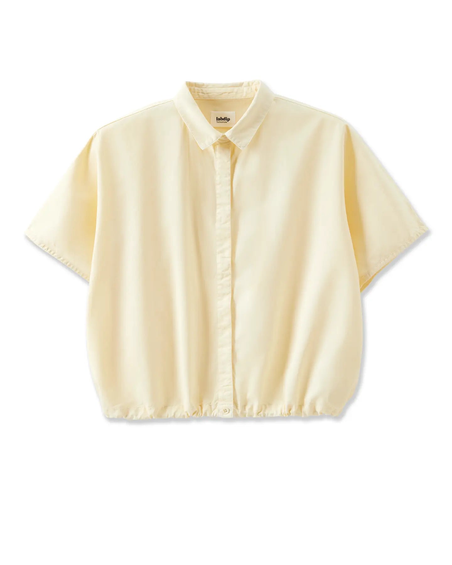 Blusa de mujer en popelín color vainilla, corte holgado con manga corta y cuello clásico, tejido ligero y fluido ideal para el verano.