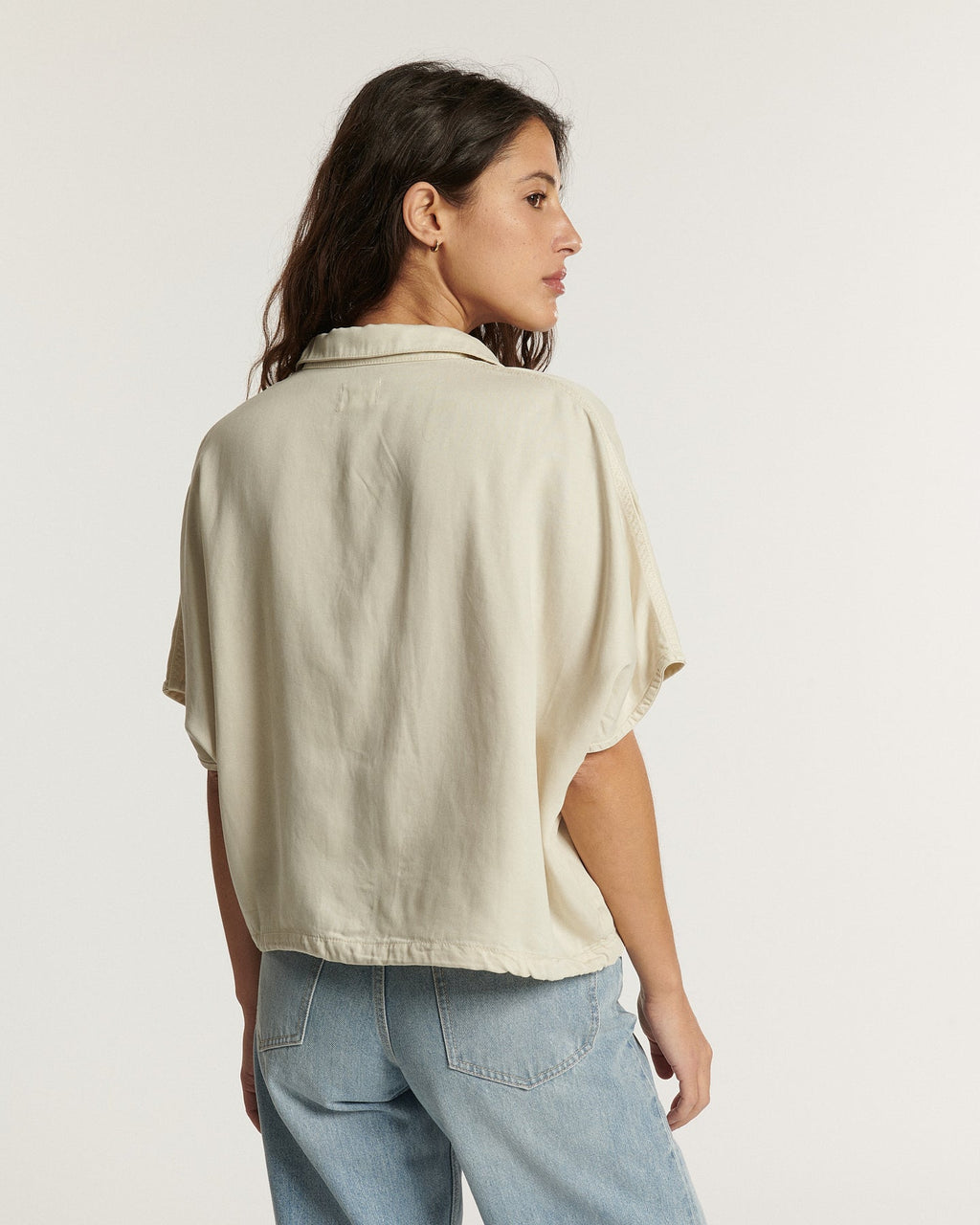 Jean femme en denim clair de couleur écume, coupe droite et confortable, matière légèrement texturée avec un aspect délavé naturel pour un style estival décontracté.