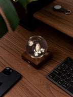 Gingko Design – Amber Crystal Light - Uil en Maan, een oplichtende kristallen bol met een uil en de maan op een houten bureau