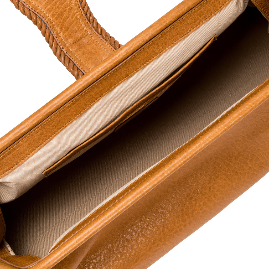 Close-up of a light brown leather bag with a white interior and card slots
