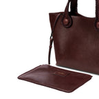 Burgundy leather in a shade of dark cherry tote bag with rope handles on a white background. It has a  removable inner bag in same color tone.
