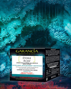 Laboratorio Antiedad y Antiarrugas Garancia [ ESTRELLA del día ] - Pack Eco-Recarga Garancia Crema Voluminizadora Suprema de Rosas [ ESTRELLA del día ] Meno-expert. La caja negra se presenta en un gélido ambiente azul turquesa y rojo. El envase menciona un 97% de ingredientes de origen natural y una acción antiarrugas y antiflacidez para rostro y cuello.