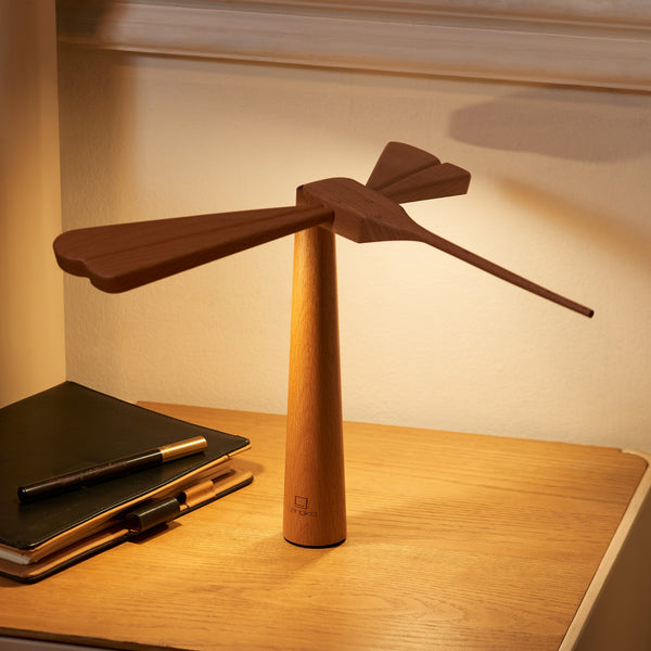 Gingko Design – Luz Libélula - Arce, lámpara de noche de madera clara y oscura, encendida, sobre una mesa
