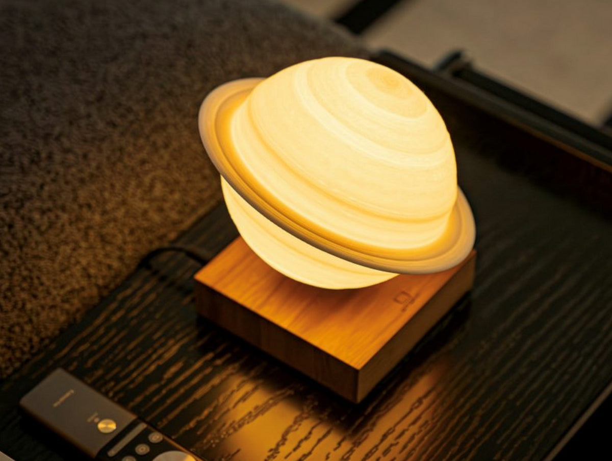 Gingko Design – Lámpara Smart Saturno - Nogal, lámpara de noche con forma de planeta Saturno, colocada sobre una mesita de noche