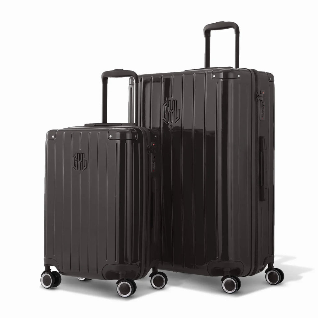 Duo of GYL Intemporelle rigid suitcases in black with ribbed shells and telescopic handles. #couleur_noir