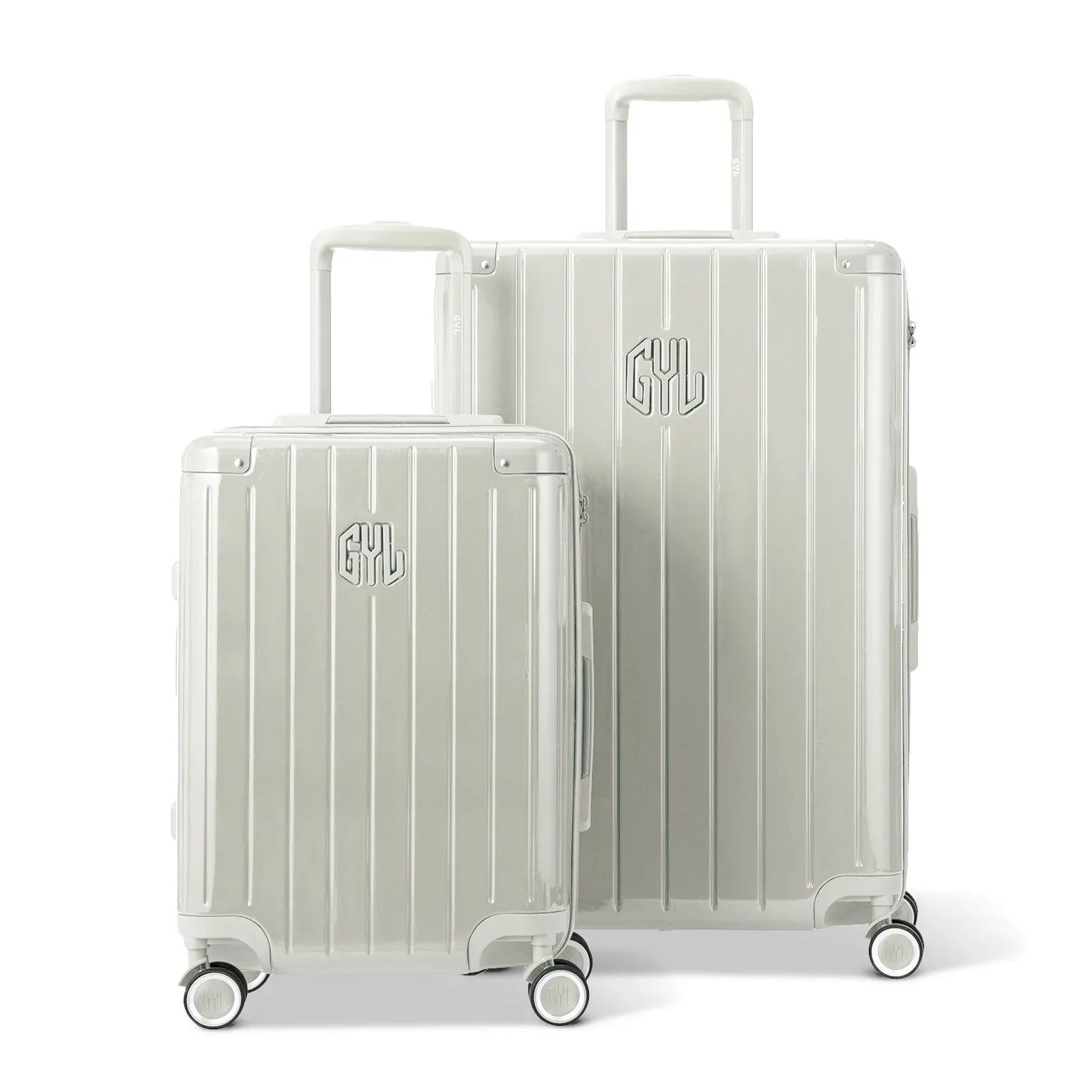 Two GYL Intemporelle sand hard-shell suitcases, cabin and hold sizes, with trolley handle extended. #couleur_sable