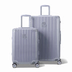 Two GYL Intemporelle silver hard-shell suitcases, cabin and hold sizes, with extended trolley handle. #couleur_argent