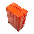 Angled view of the GYL Intemporelle orange hard-shell suitcase with reinforced corners and glossy ribbed shell. #couleur_orange foncé