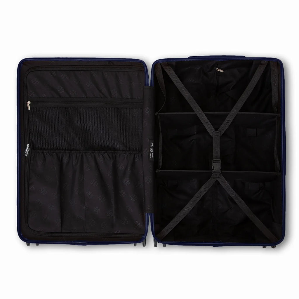 Compartmentalised interior of the GYL Intemporelle navy suitcase with cross straps and mesh pockets. #couleur_marine