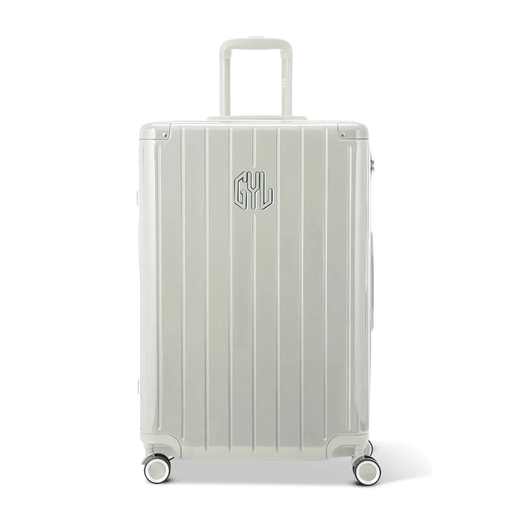 Front view of the GYL Intemporelle sand hard-shell suitcase, embossed logo and 360-degree wheels. #couleur_sable