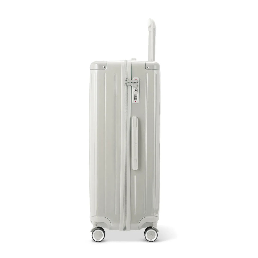 Side view of the GYL Intemporelle sand hard-shell suitcase with telescopic handle and TSA lock. #couleur_sable