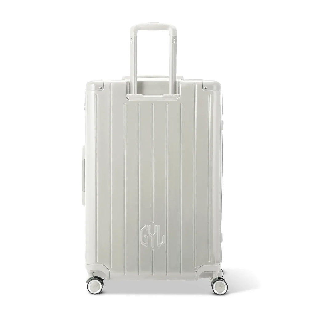 Rear view of the GYL Intemporelle sand hard-shell suitcase with integrated handles and swivel wheels. #couleur_sable