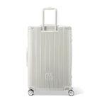 Rear view of the GYL Intemporelle sand hard-shell suitcase with integrated handles and swivel wheels. #couleur_sable