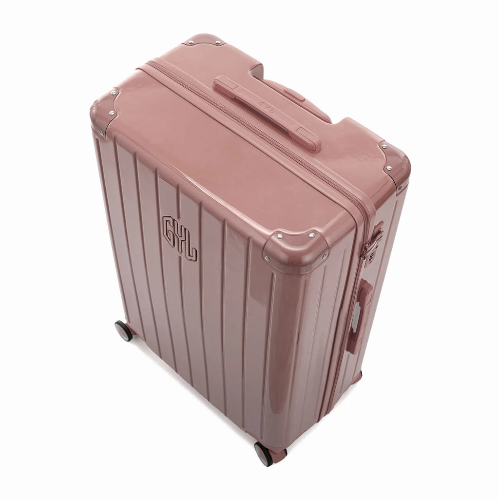 Vista en ángulo de la maleta rígida GYL Intemporelle oro rosa con esquinas reforzadas y carcasa nervada brillante. #couleur_rose gold
