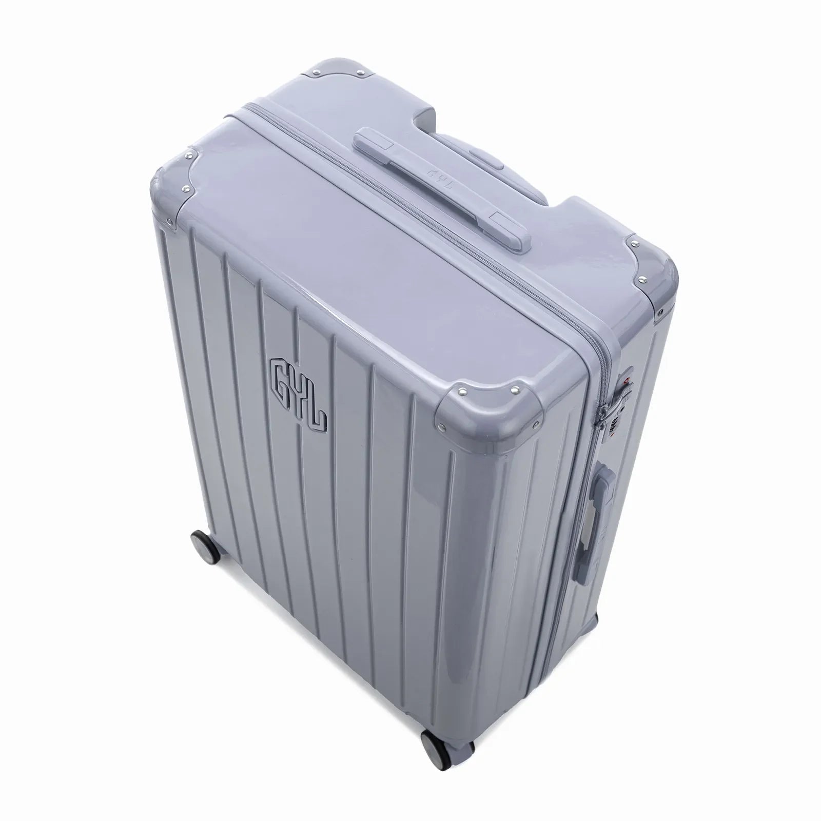 Angled view of the GYL Intemporelle silver hard-shell suitcase with reinforced corners and glossy ribbed shell. #couleur_argent