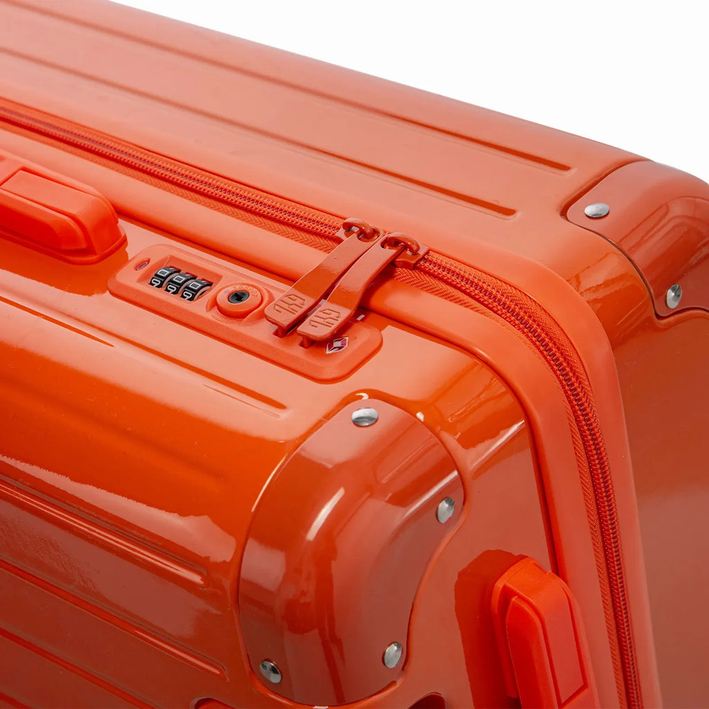 TSA combination lock and GYL double zip slider on the Intemporelle orange hard-shell suitcase. #couleur_orange foncé