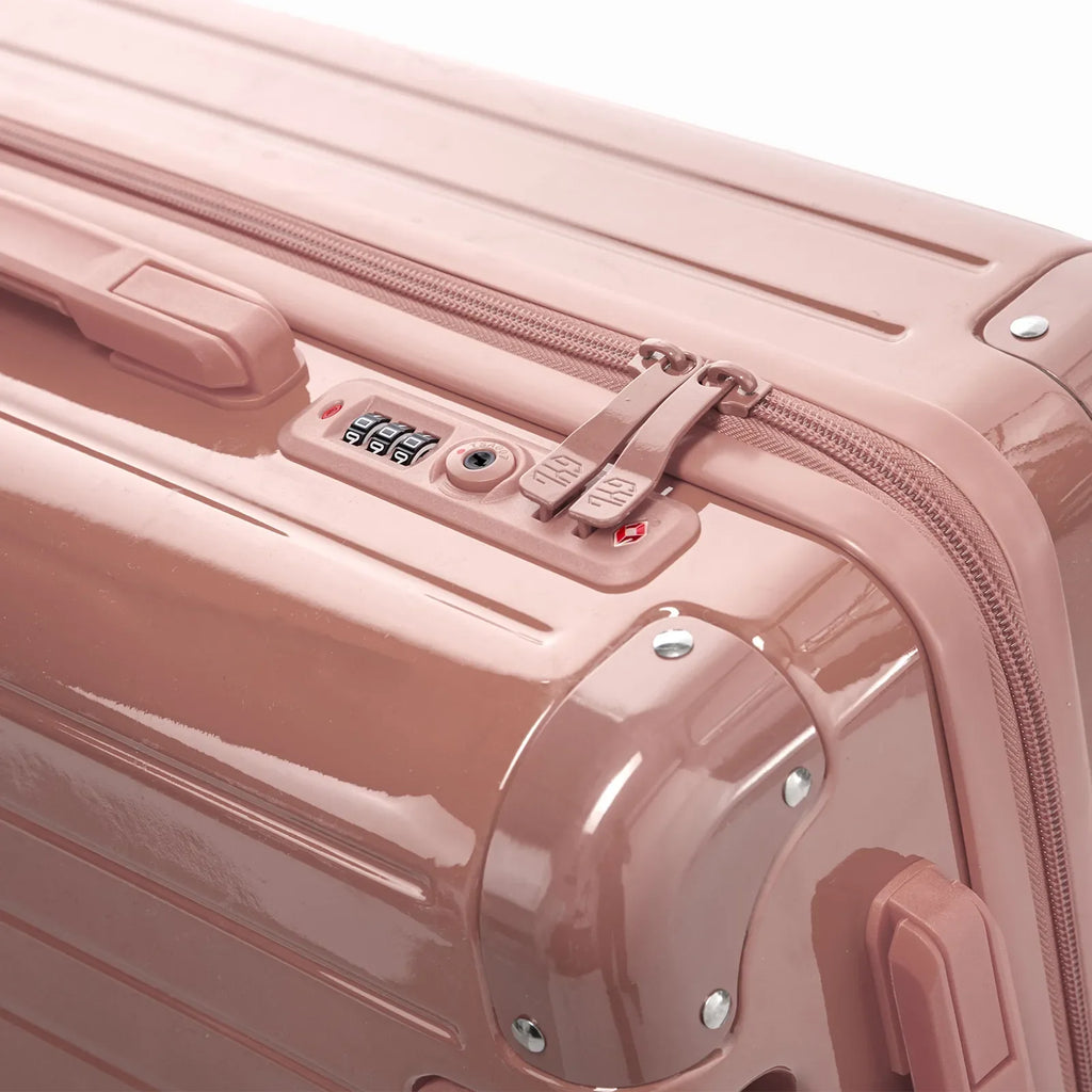 TSA combination lock and double GYL zip slider on the Intemporelle rose gold hard-shell suitcase. #couleur_rose gold