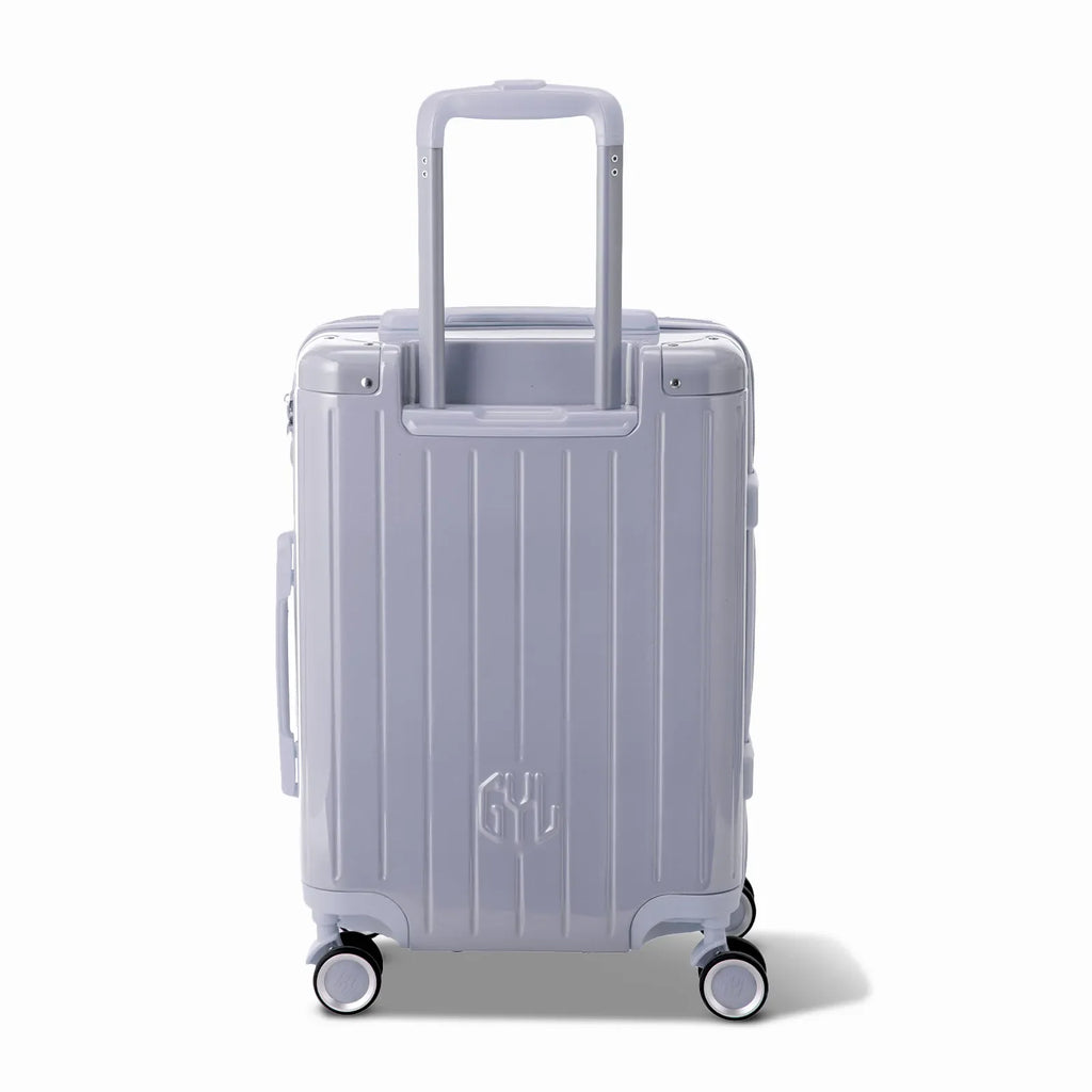 Rear view of the GYL Intemporelle silver hard-shell suitcase with integrated handles and spinner wheels. #couleur_argent