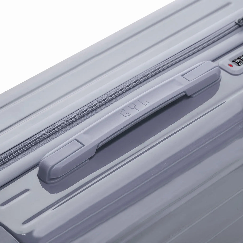 Rigid top handle of the GYL Intemporelle silver suitcase with embossed logo on top. #couleur_argent