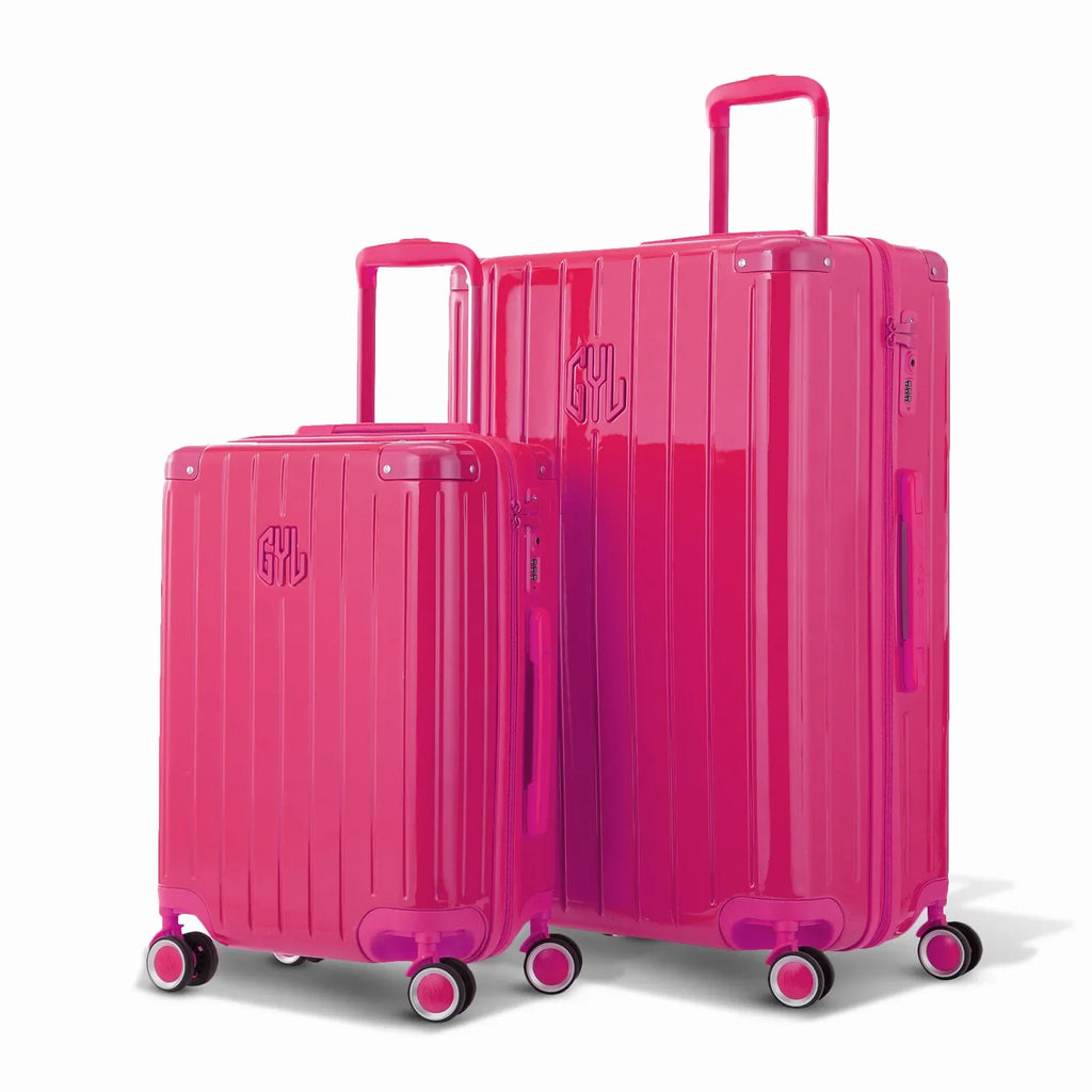 Duo of GYL Intemporelle fuchsia hard-shell suitcases with ribbed shells and telescopic handles. #couleur_fuchsia