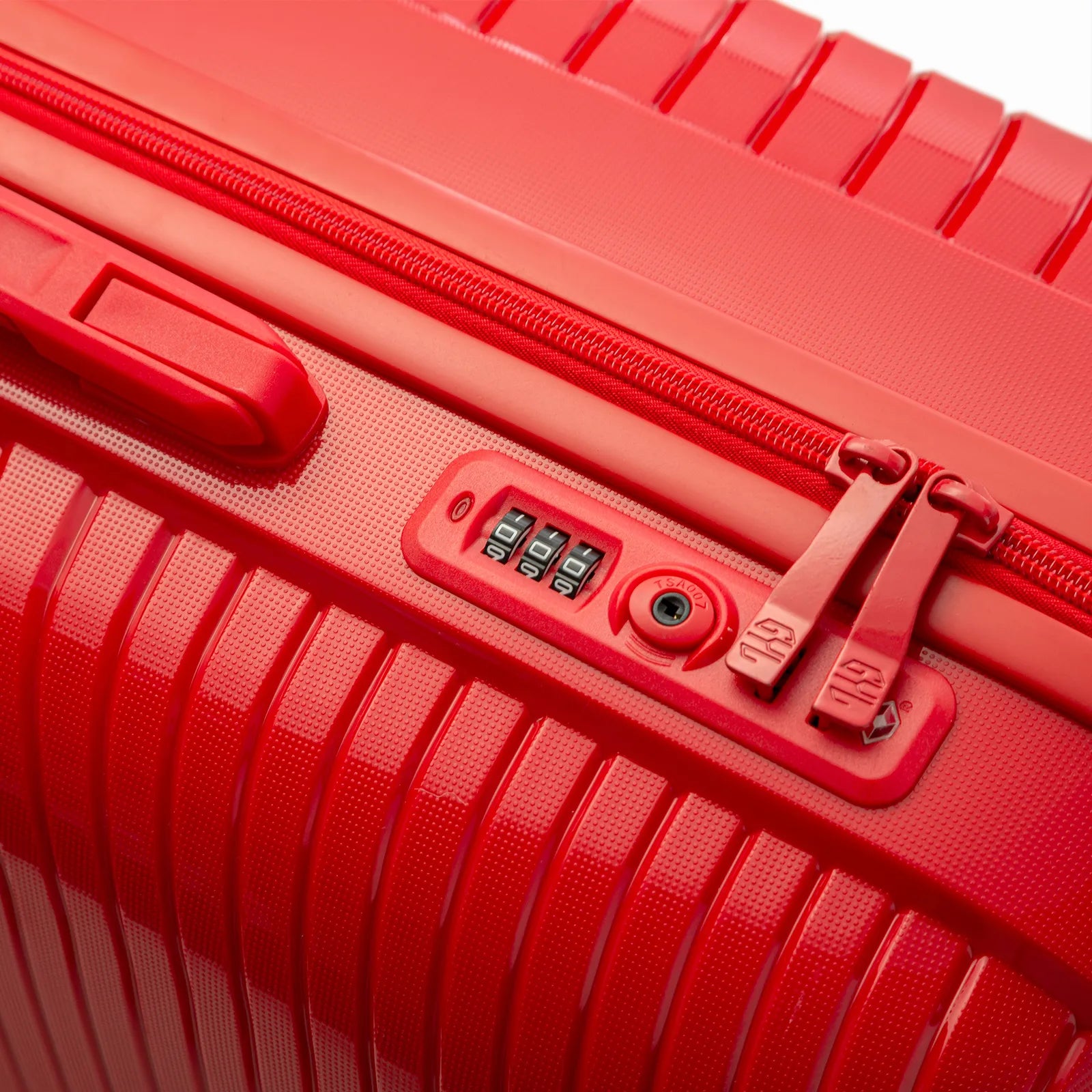 Detail of the integrated TSA lock and zippers on the red Signature suitcase. #couleur_red