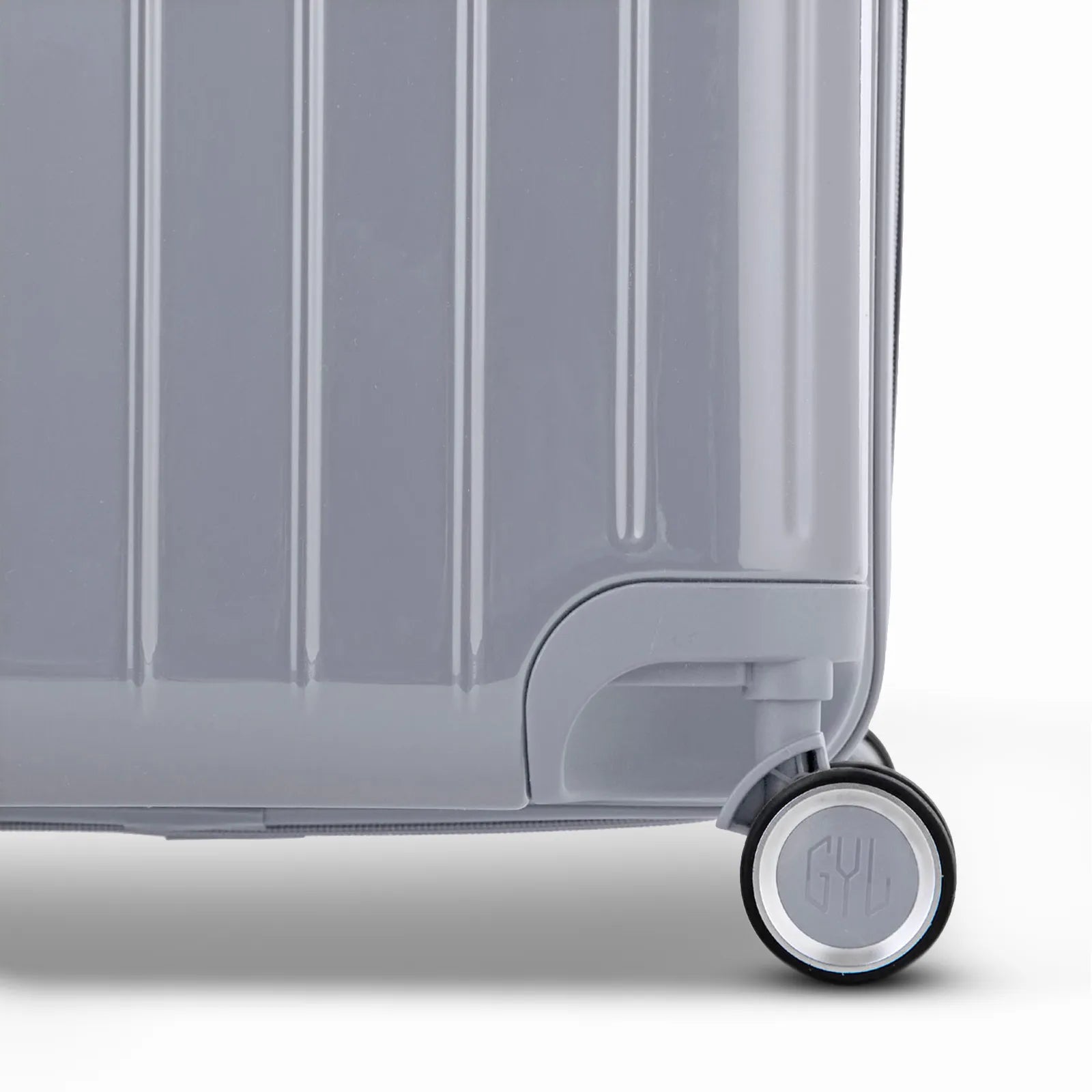 Detail of the wheel and GYL logo on the bottom of the silver trunk suitcase in glossy polycarbonate. #couleur_argent