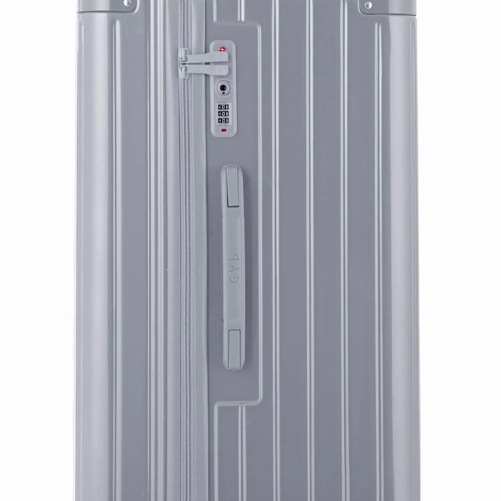 Detail of the TSA lock and side handle on the silver trunk suitcase. #couleur_argent