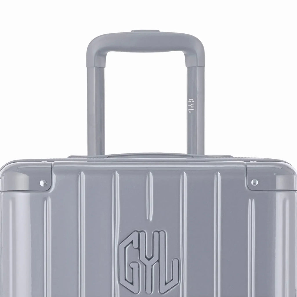 Close-up on the trolley handle and GYL logo of the silver trunk suitcase. #couleur_argent