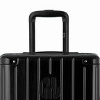 Close-up on the trolley handle and GYL logo of the black trunk suitcase. #couleur_noir
