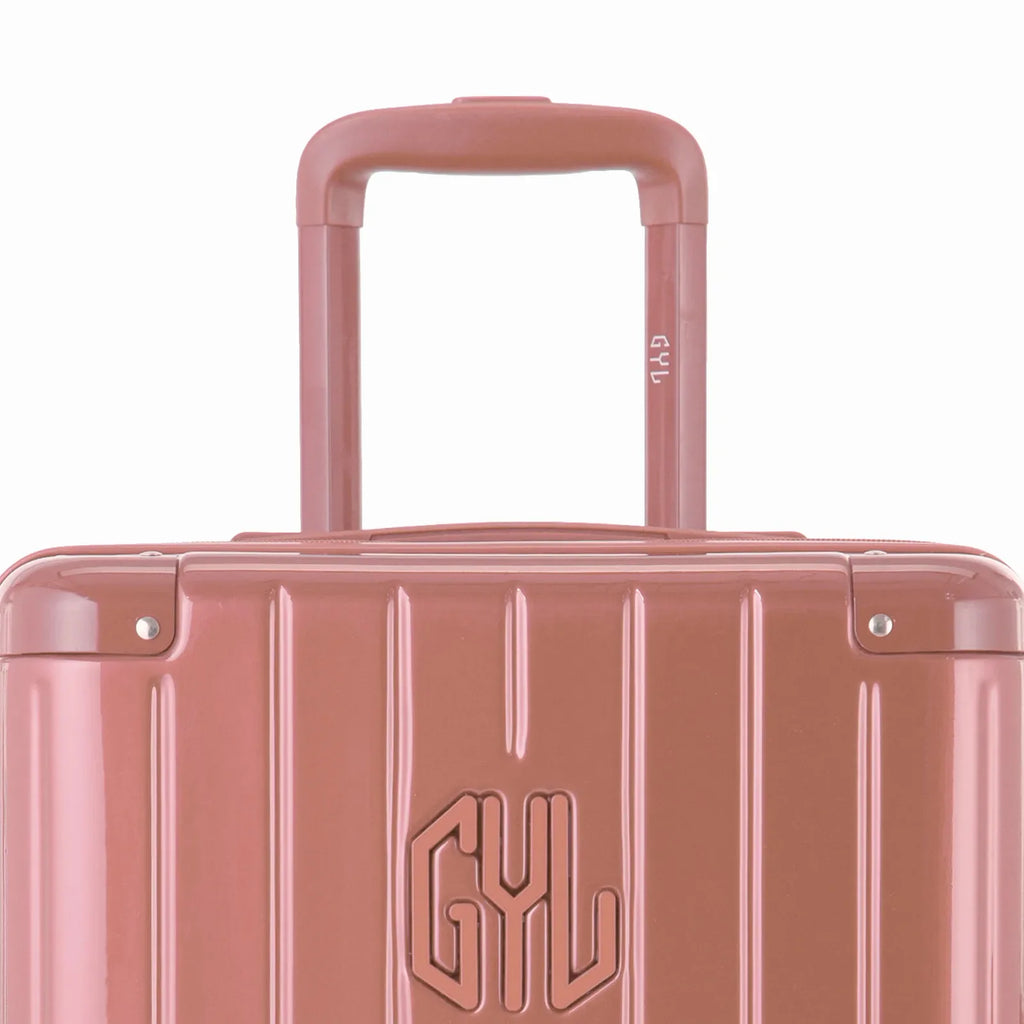 Close-up on the trolley handle and GYL logo of the rose gold trunk suitcase. #couleur_rose gold