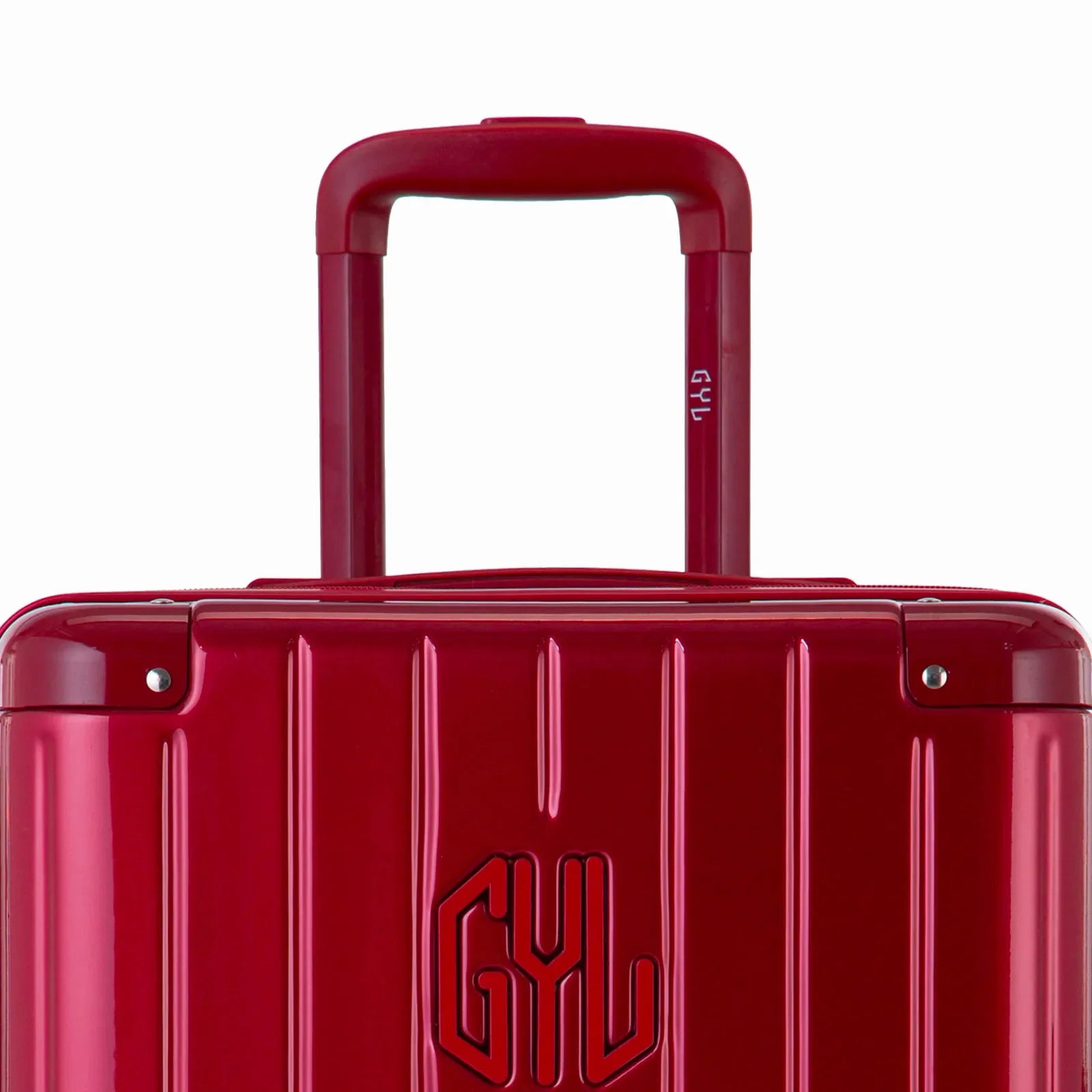 Close-up on the trolley handle and GYL logo of the dark red trunk suitcase. #couleur_red foncé